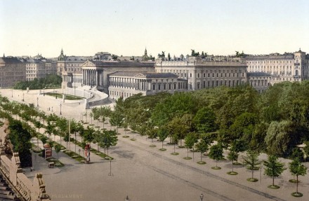 Das k.u.k. Reichsratsgebäude (heute Parlament) an der Wiener Ringstraße um 1900, aufgenommen vom Burgtheater aus; rechts der Rathauspark. Quelle: Wikimedia Commons