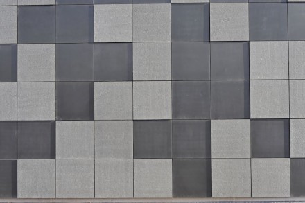 Die Fassade ist mit Basaltplatten einer einzigen Größe (91,7 x 91,7 cm) verkleidet, so dass man in ihr durchaus ein hochaufgelöstes Pixelmuster sehen kann.