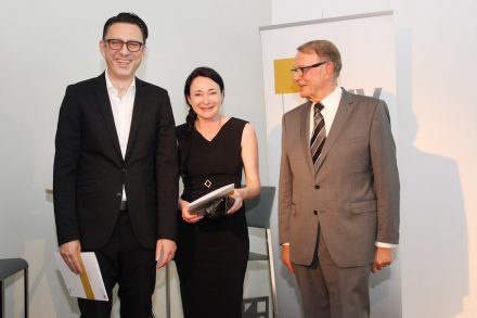 Manfred Wenzel, Geschäftsführer TEK TO NIK Architekten (li) und Maja Wal, Prokuristin von TEK TO NIK Architekten, bei der Verleihung des Deutschen Natursteinpreises 2015 mit Joachim Grüter (re), Präsident des Deutschen Naturwerkstein-Verbandes (DNV). Foto: NürnbergMesse / Thomas Geiger