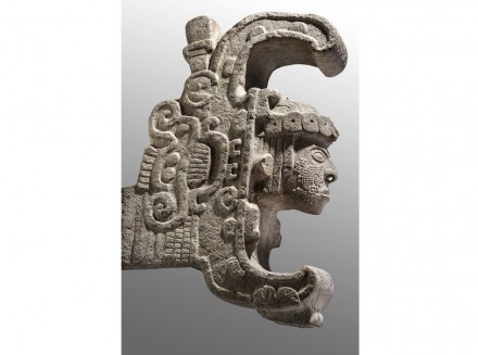 Die Königin von Uxmal. Kalkstein, 600-900 n. Chr, INAH, Mexiko-Stadt. Die Skulptur stammt von der Hauptfassade der Zauberer-Pyramide: Aus einem stilisierten, aufgerissenen Schlangenmaul kommt ein menschlicher Kopf hervor mit Ohrschmuck, einer durchstochenen Nase und einer Kopfbedeckung aus Jadescheiben. Dargestellt ist vielleicht ein Ritual, bei dem der Herrscher symbolisch von einer Boa verschlungen worden war, um mit den Kräften eines Schamanen wiederzukehren.