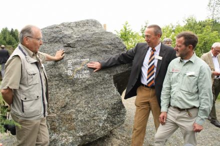 Drei Mitglieder der Projektgruppe des Themenpfades mit einem der vielen „dicken Brocken“, die bewegt wurden: (v.l.n.r.) Willi Grope, Dr. Siegfried Klingebiel, Revierförster Rainer Hoffmeister. Foto: Niedersächsische Landesforsten