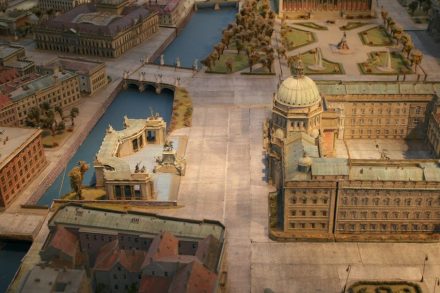 Das Stadtmodell, zu sehen in der Humboldtbox, zeigt links vom Schloss das ehemalige Einheitsdenkmal mit den Kolonnaden dahinter. Auf der anderen Spreeseite angeschnitten Schinkels Bauakademie mit der Backsteinfassade.
