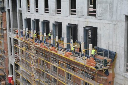 Eine der Besonderheiten am neuen Berliner Stadtschloss ist, dass die Naturstein-Fassade nicht vorgehängt ausgefertigt wurde. Vielmehr gibt es vor der Betonwand eine Klinkerwand, in die die teils tonnenschweren historischen Elemente aus Sandstein eingemauert sind. Foto vom Oktober 2015.