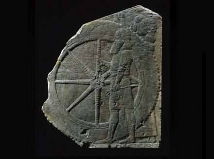 Fragment of a relief with a chariot, limestone, h. 55 cm, l. 46.5 cm.; 7th century BC, found in Nineveh. This relief was found in the northern Assyrian palace of Nineveh. It displays a bearded soldier grasping one of the large wheels of the royal chariot. The two men standing behind the wheel are holding a screen. Photo and collection of © Musée du Louvre, Paris