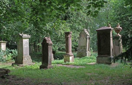 Grabmale auf dem Alten Friedhof in Pirmasens, im Hintergrund rechts die beiden ältesten. Foto: Gerd Eichmann / <a href="https://commons.wikimedia.org/wiki/File:Pirmasens-Alter_Friedhof-21-Grabdenkmale-gje.jpg"target="_blank">Wikimedia Commons</a>