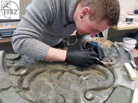 Ein Kursteilnehmer bei der Rissinjektion an einem Spitzbogentympanon aus Molasse Sandstein.