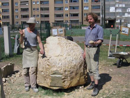 Die Steinbildhauer Michael Spengler (links) und Ole Meinecke (rechts) im Jahr 2006, als sie einen Sandsteinblock in ein Denkmal für die Berliner Schrippe umwandelten. Das Kunstwerk ist inzwischen am Standort der ehemaligen Schrippenkirche im Bezirk Wedding aufgestellt: Dort erhielt von 1880 an jeder Obdachlose, der die sonntäglichen Gottesdienste besuchte, ein Frühstück bestehend aus einem Becher Kaffee und 2 Brötchen.