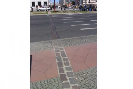 A ribbon of cobblestone meanders through the center of Berlin where the Wall formerly separated the city. Photo: Shizhao / <a href="https://commons.wikimedia.org/"target="_blank">Wikimedia Commons