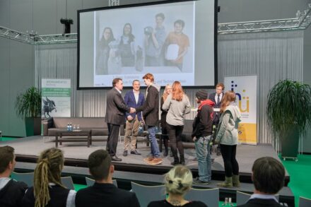 Übergabe der Urkunden an das Team der Fachschule für Steingestaltung und Steintechnik in Hallein auf der Bühne der Messe Monumento am 5. März 2020. Links Bundesinnungsmeister Wolfgang Ecker und BIM-Stellvertreter Ing. Norbert Kienesberger, Anna Singer (GF Steinzentrum Hallein, 4.v.l.) und Juror Dr. Arnold Reinthaler (2.v.r.). Foto: Richard Watzke