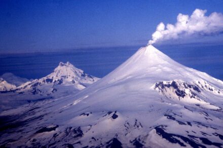 Shishaldin, Isanotski, and Roundtop Volcanoes lined up in a row on a rare crystal clear Aleutian day. Alaska, Aleutian Islands. Source: Allan Shimada, NOAA NMFS/OST/AMD / <a href="https://commons.wikimedia.org/"target="_blank">Wikimedia Commons</a>, <a href=" https://en.wikipedia.org/wiki/Creative_Commons_license"target="_blank">Creative Commons License</a>