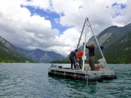 Das Team vom Institut für Geologie entnimmt von einer schwimmenden Bohrplattform bis zu 8 Meter lange Bohrkerne aus dem Plansee im Tiroler Bezirk Reutte. Foto: Jasper Moernaut