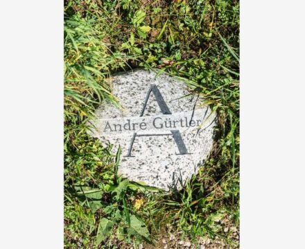 A Maggia stone was laid on the cemetery meadow for the gravestone. The deceased was a font-designer - the large letter is symbolic of his work and his name was engraved in a light vein running across the stone. The date was omitted. Sculptor: Alessandro Rossi, sculptor's studio, Allschwil.