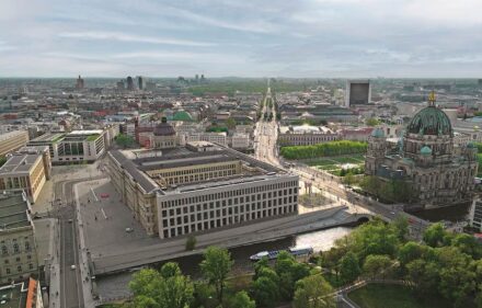 Luftaufnahme des Humboldt Forums aus Richtung Alexanderplatz (vor der Aufstellung der Skulpturen). Am Ende der Straße Unter den Linden das Brandenburger Tor. Quelle: Stiftung Humboldt Forum im Berliner Schloss / Boheifilm