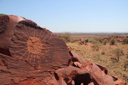 Circle and radiating lines geometric motif located on the Southern Burrup with a high contrast state. Photo: A. Stevens / Unesco