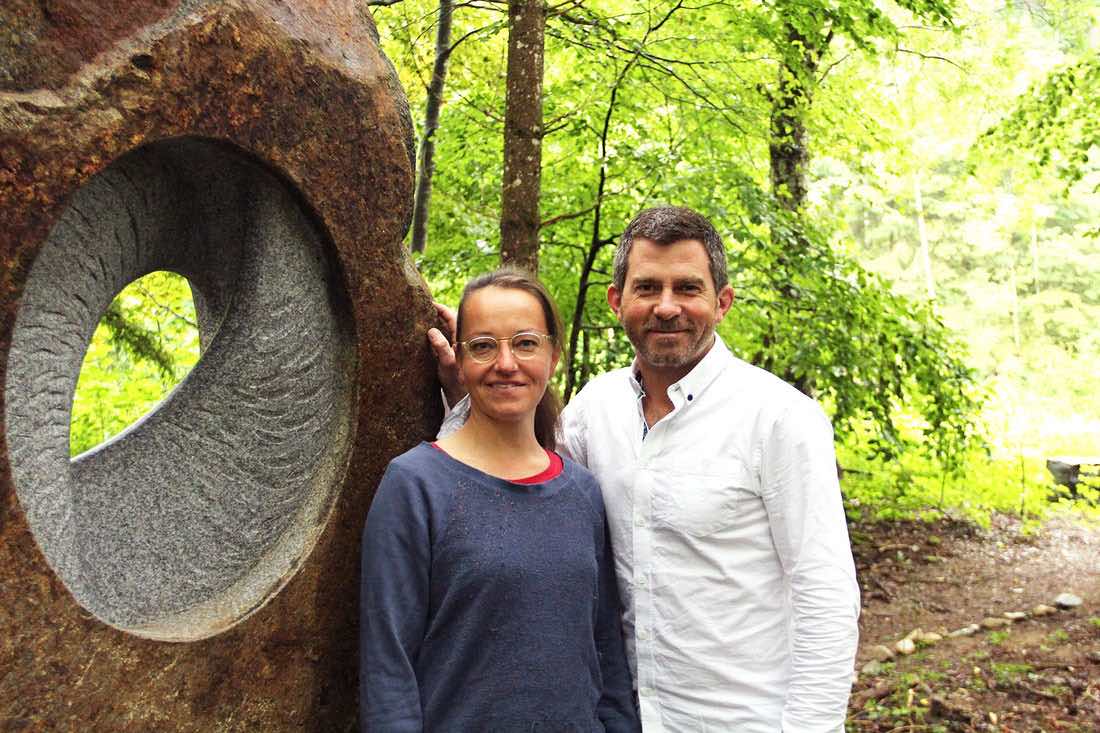 TOBEL & Christiane Ahlhelm neben einer Steinskulptur des Bildhauers.