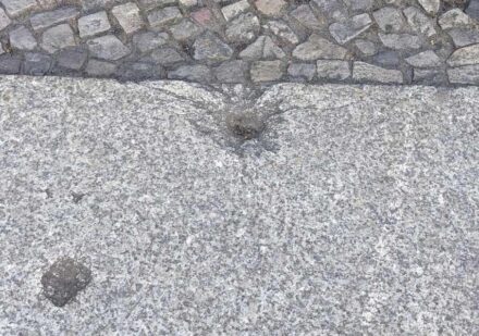 Zeitsprung zurück in die Jahre 1943 bis 1945: Löcher in den Gehwegplatten aus Granit erzählen von den Bombennächten in Berlin und anderswo