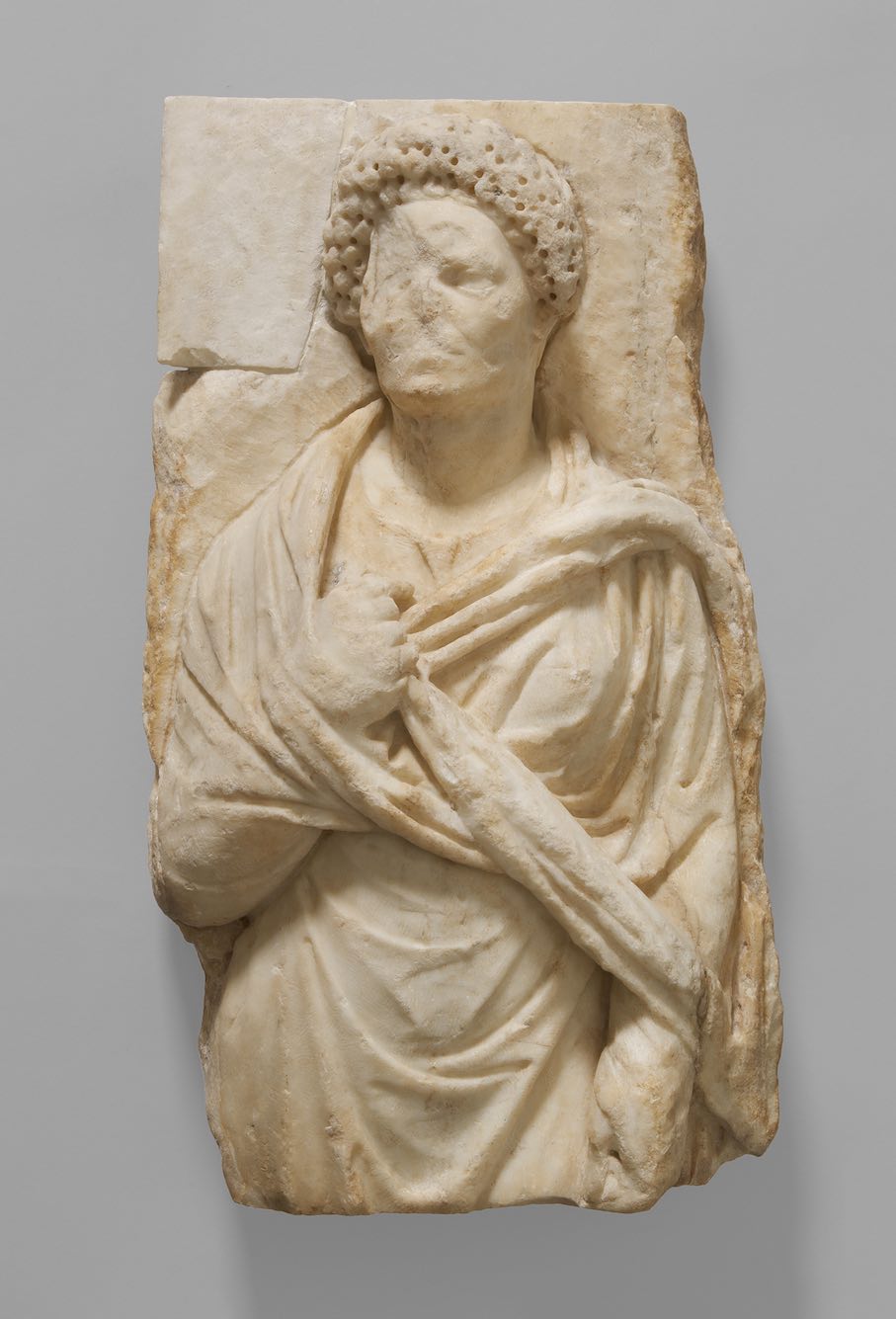 Grabrelief mit stehender Frau. Römisch-attisch; spätes 1. / frühes 2. Jh., flavisch- trajanisch. Marmor; linke Bildhälfte fehlt, linke obere Ecke neuzeitlich ergänzt. © KHM-Museumsverband