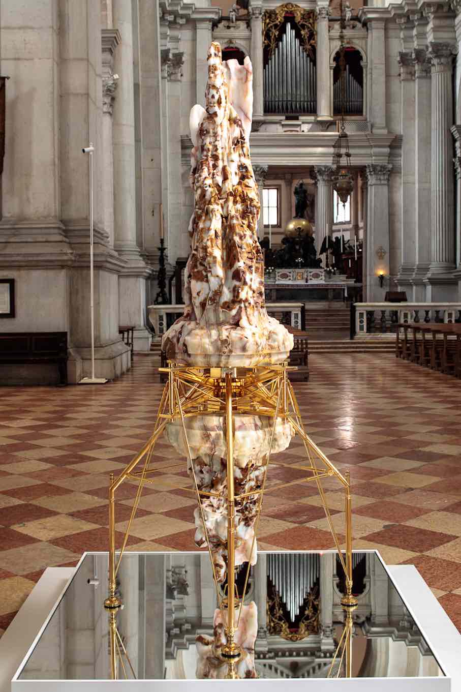 “Enthroned Pope, Reflected,” 2013–2024. Sculpture: translucent “wounded” Mexican onyx, 24K gold-plated steel and aluminum, stainless steel; base: lacquered solid aluminum, optical mirror, stainless steel.